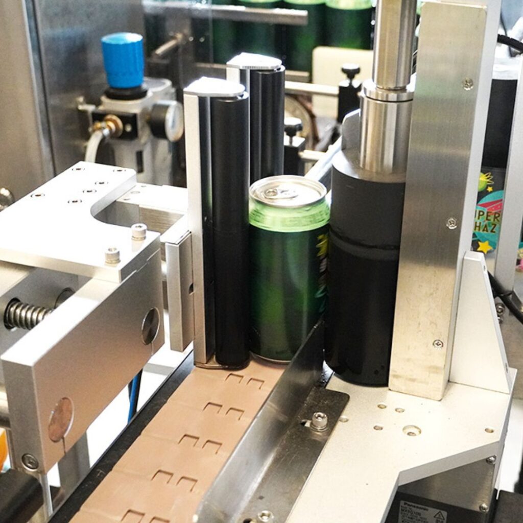 Automated labelling machine applying labels to craft beer cans.