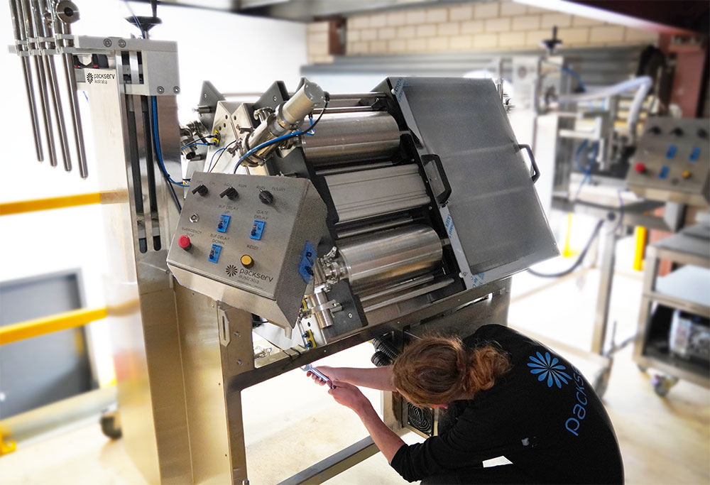 PFM-5 4C multi-head liquid filler by Packserv Australia, angled view, showing stainless steel body and multiple nozzles